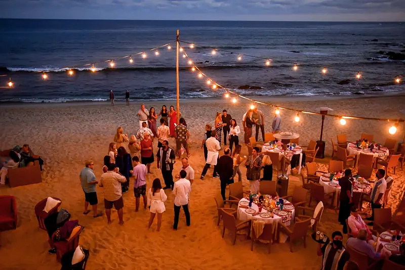 Beach dinner under string lights at dusk