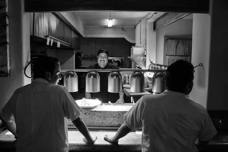 Kitchen team at the pass, in black and white