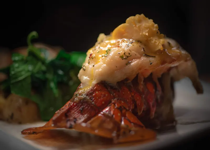 Lobster tail plated over greens