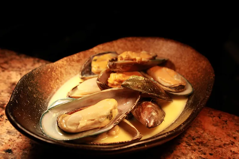 Mussels in a creamy broth on a rustic plate