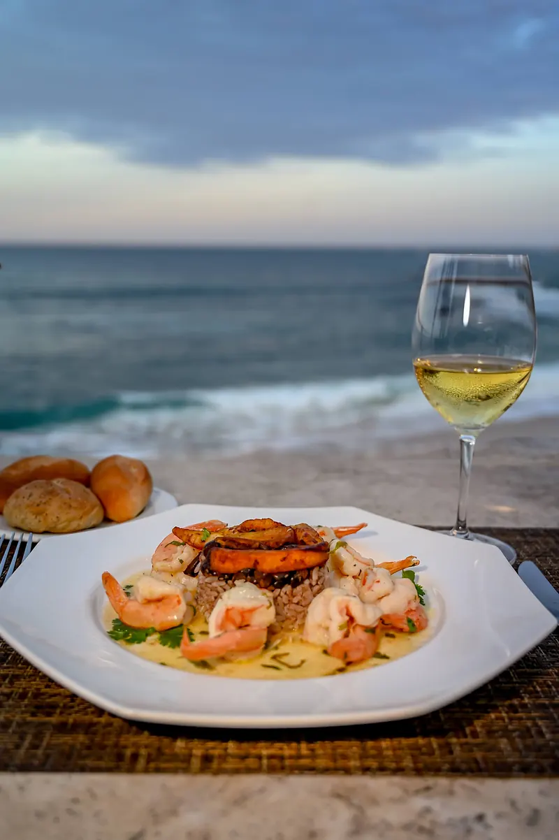 Seafood plate and white wine beside the beach at dusk
