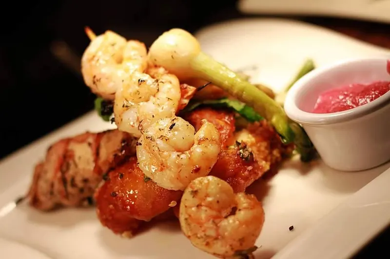 Grilled shrimp skewers with a pink sauce