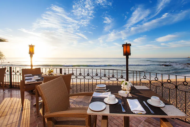 Terrace tables at sunset overlooking the ocean