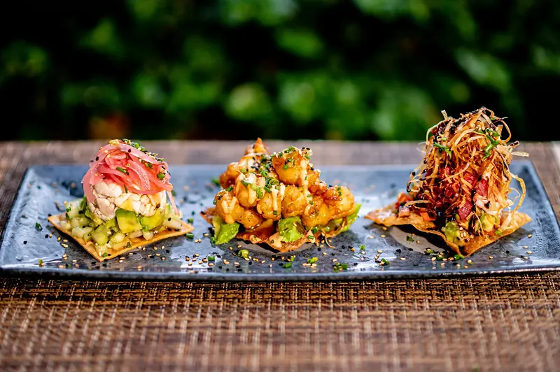 Three seafood tostadas on a blue plate